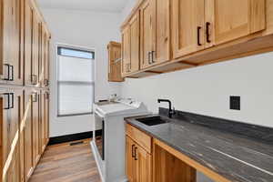 Laundry area with cabinet space, light wood-style flooring, and washer and clothes dryer