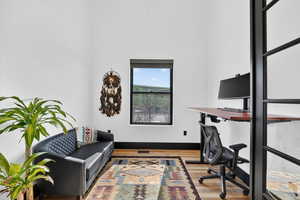 Home office with light wood-type flooring and baseboards
