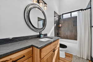 Bathroom featuring vanity, light wood finished floors, and shower / tub combo with curtain