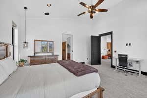 Bedroom with light carpet, a high ceiling, ceiling fan, an office area, and recessed lighting