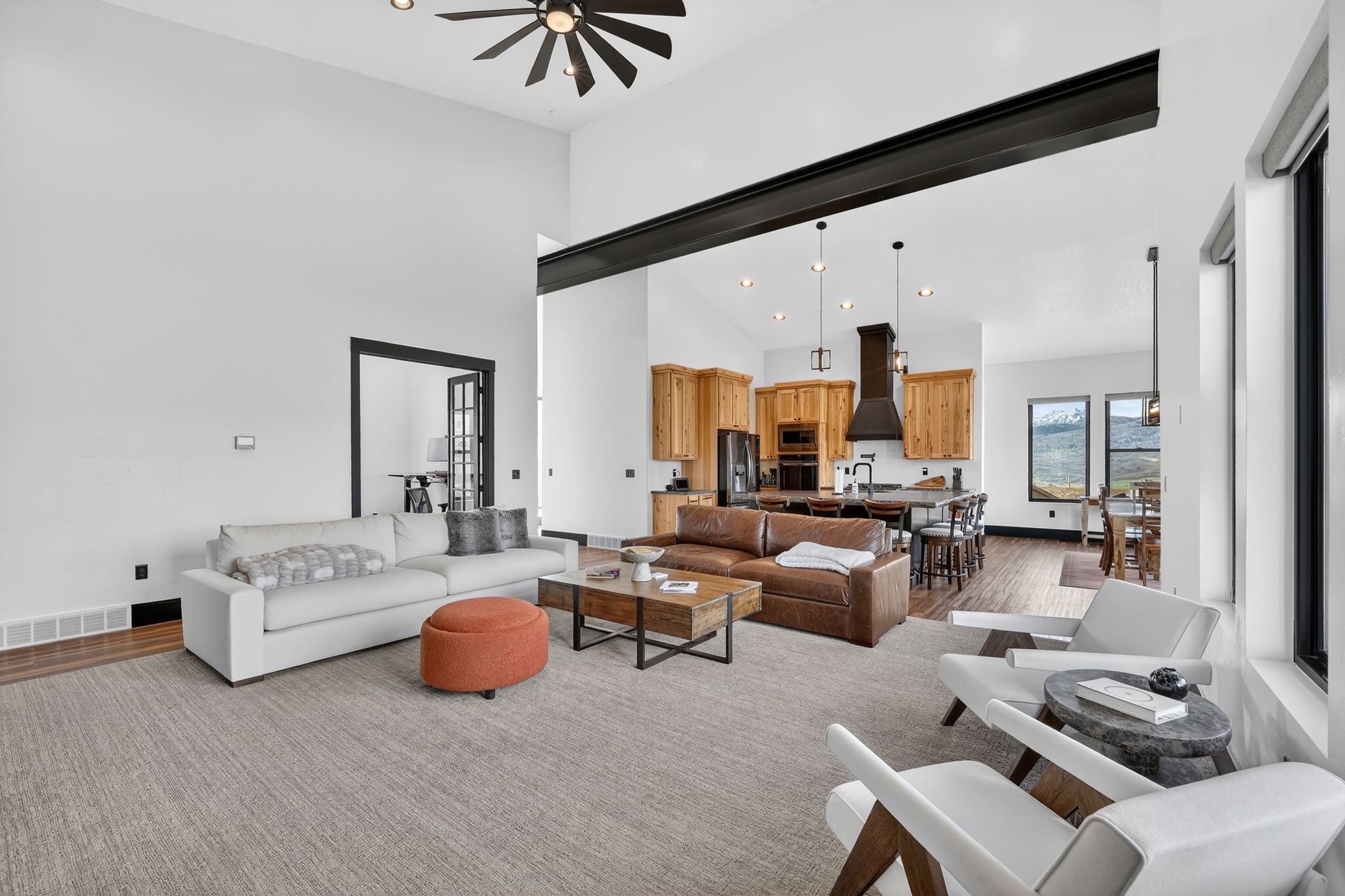 Living area featuring wood finished floors, recessed lighting, a ceiling fan, and a high ceiling