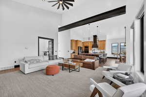 Living area featuring wood finished floors, recessed lighting, a ceiling fan, and a high ceiling
