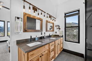 Bathroom with double vanity, ensuite bath, a mountain view, and dark tile patterned flooring