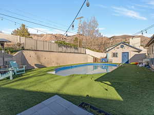 View of pool with patio surround, a mountain view, and a fenced backyard