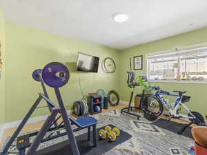 Workout area featuring baseboards and light wood finished floors