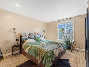 Bedroom with light wood finished floors and recessed lighting