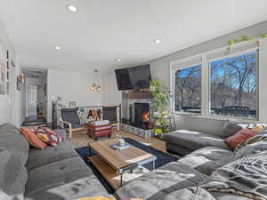 Living room featuring wood finished floors, a fireplace, and recessed lighting