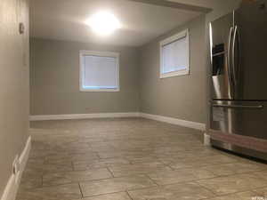 Interior space with stainless steel fridge with ice dispenser and baseboards