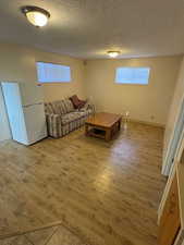 Living room with a textured ceiling and light wood finished floors