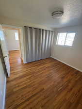 Spare room featuring wood finished floors and a textured ceiling
