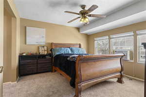Bedroom featuring light colored carpet, a textured ceiling, ceiling fan, and cooling unit