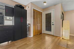 Kitchen with dark cabinets and light wood-style flooring