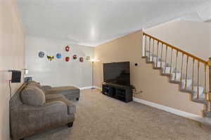 Living room featuring a textured ceiling and light colored carpet