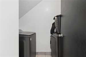 Laundry room featuring independent washer and dryer and light tile patterned floors