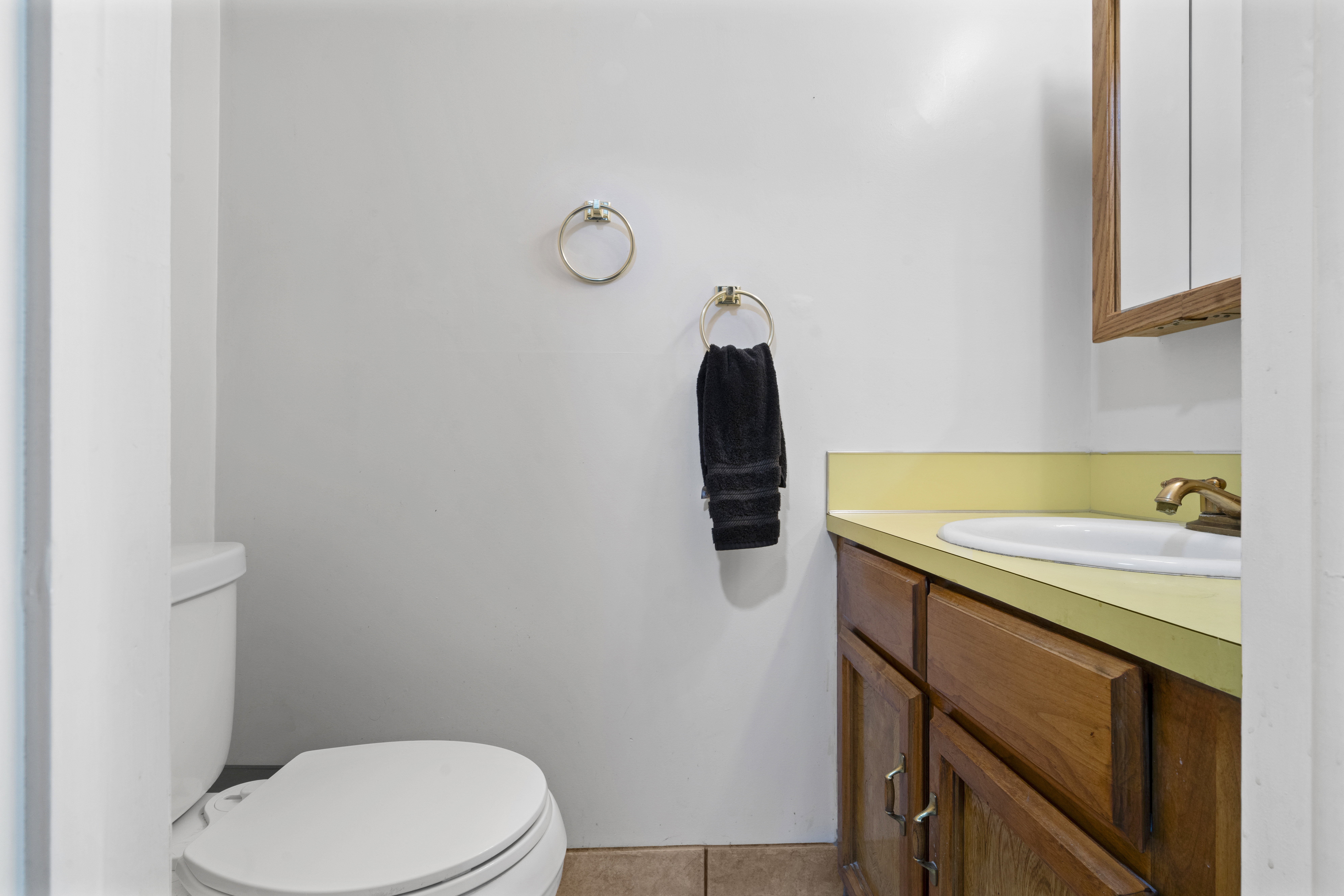 Half bath with vanity and light tile patterned floors