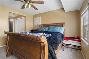 Bedroom with light carpet, a closet, and a ceiling fan