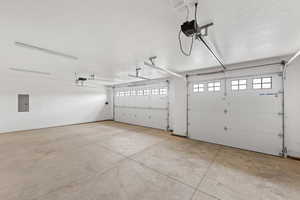 Garage featuring electric panel and a garage door opener