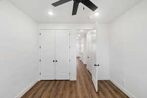 Unfurnished bedroom featuring dark wood-style floors, a closet, ceiling fan, and recessed lighting