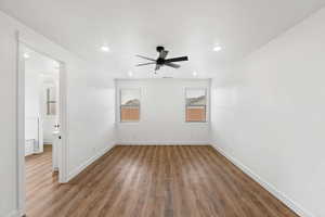 Spare room featuring dark wood-style floors, a ceiling fan, and recessed lighting