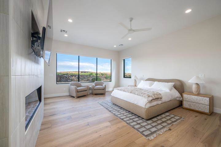 Bedroom with light wood-style flooring, a fireplace, a ceiling fan, and recessed lighting