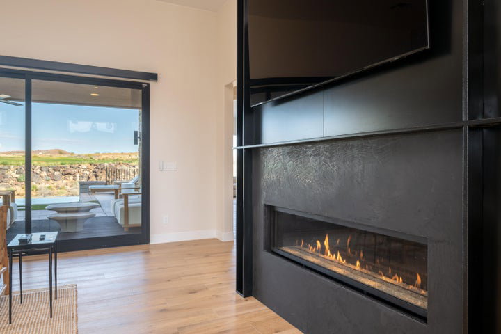 Detailed view of wood finished floors and a premium fireplace