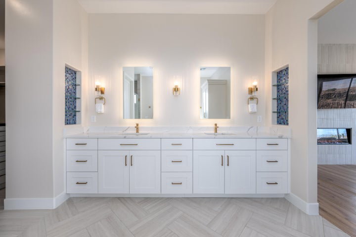 Full bathroom with double vanity, parquet floors, and a fireplace