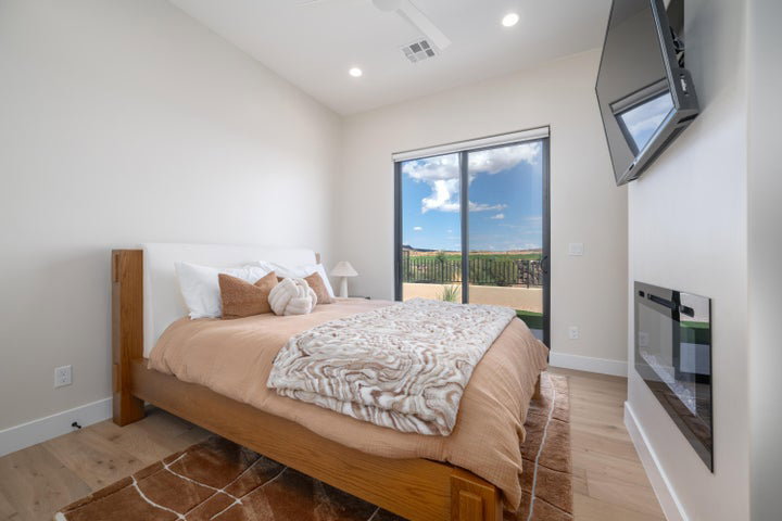 Bedroom with access to outside, light wood-type flooring, vaulted ceiling, ceiling fan, and recessed lighting