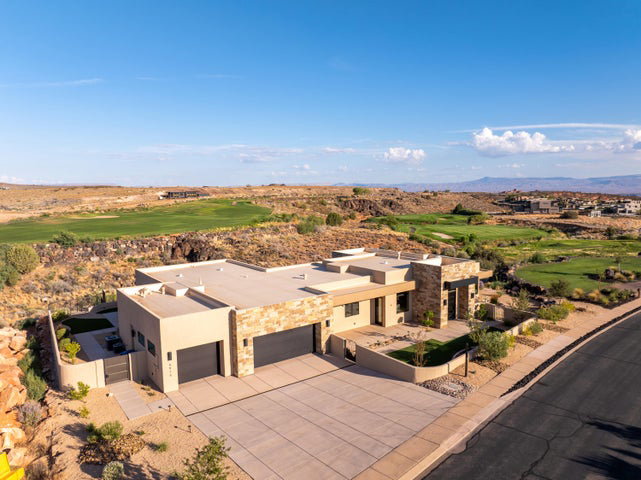 Aerial view of property and surrounding area featuring a local golf course and a mountain backdrop