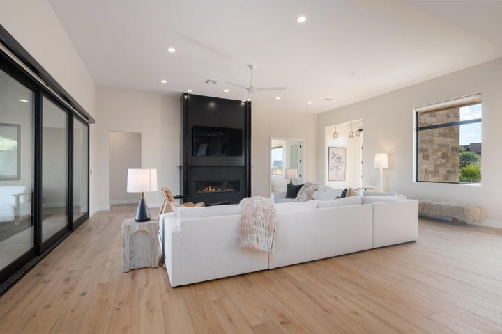 Living area featuring light wood-type flooring, a large fireplace, recessed lighting, and ceiling fan