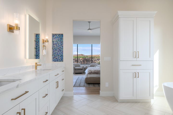 Bathroom featuring double vanity, a soaking tub, a ceiling fan, ensuite bathroom, and parquet flooring