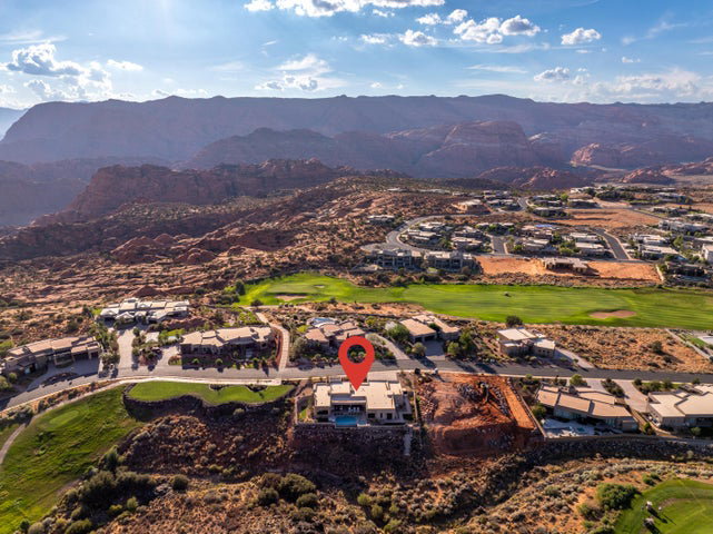 Aerial view of residential area with a golf club and a mountainous background