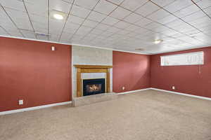 Unfurnished living room featuring carpet flooring and a fireplace