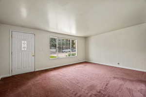 Foyer entrance featuring carpet floors and baseboards