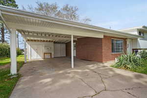 View of parking featuring a carport, workshop,  and driveway