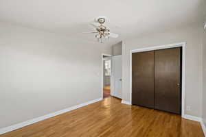 Unfurnished bedroom with a closet, light wood-type flooring, and a ceiling fan