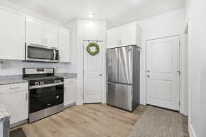Kitchen featuring stainless steel appliances, white cabinetry, granite countertops and a pantry!