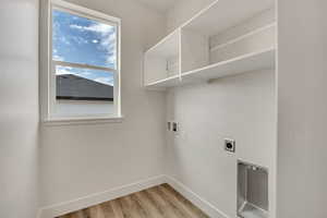 Laundry area with washer hookup, light wood finished floors, and hookup for an electric dryer
