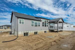 Rear view of property with a shingled roof and a deck