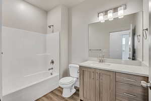 Bathroom featuring vanity, light wood-style floors, and washtub / shower combination