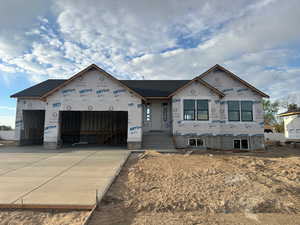 Property in mid-construction featuring an attached garage and driveway
