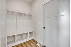Mudroom with light wood-style flooring and baseboards