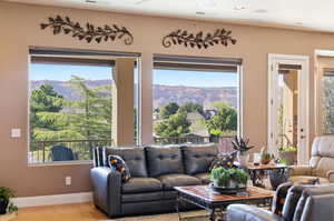 Living area with a mountain view, ceiling fan, and wood finished floors