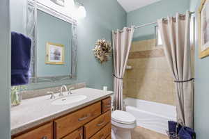 Bathroom with vanity, shower / tub combo, and light tile patterned floors