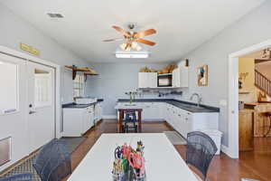 Kitchen featuring dark countertops, white cabinetry, and a ceiling fan