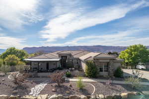 Back of house featuring stucco siding, a mountain view, stone siding, a patio, and a tile roof