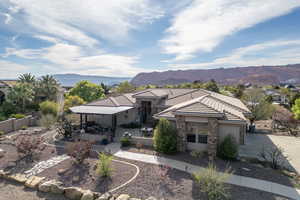 View of front of home with stucco siding, a mountain view, a tiled roof, and stone siding