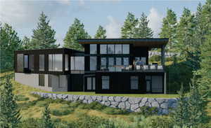 Rear view of house with a lawn, brick siding, and a balcony