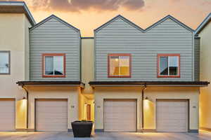 View of front of home featuring stucco siding, an attached garage, and driveway