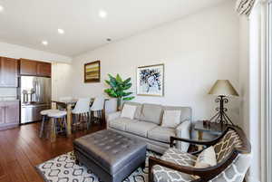 Living room with dark wood-type flooring and recessed lighting