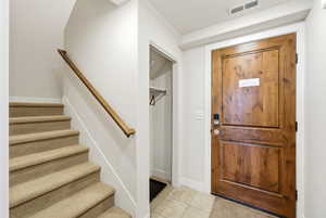 Foyer featuring stairway and light tile patterned floors